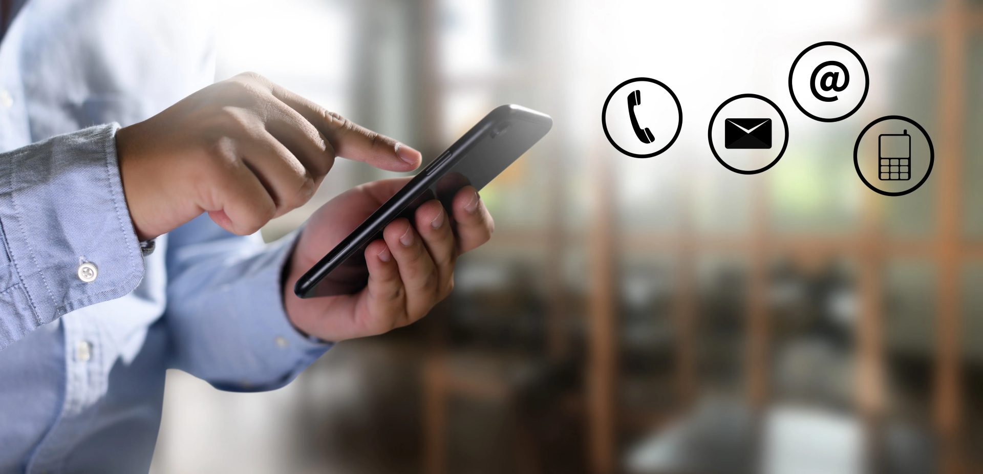 A person using a mobile phone, with phone, email and messaging icons shown alongside.
